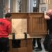 Mitarbeiter heben den Generalspieltisch der Domorgel Paderborn an und bereiten ihn für den Transport vor