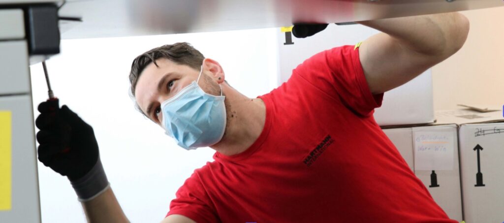 Umzugshelfer demontiert einen Schreibtisch beim Umzug der Stadtverwaltung Salzkotten